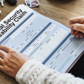 Woman filling up social security disability claim form.