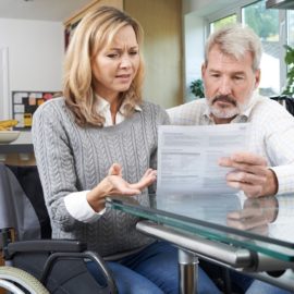 Woman in wheelchair reading her disability claim results.
